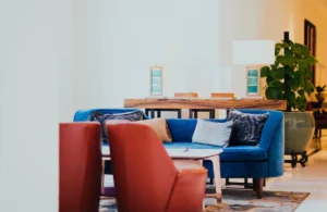 Discover the best interior colors in UAE apartments that blend modern design with comfort. This image showcases a cozy living room with blue and red furniture for an elegant look.