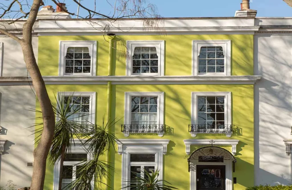 A modern villa painted in a vibrant lime green shade with white trim. This bold approach shows the creative color possibilities available with Villa Painting Dubai professionals.