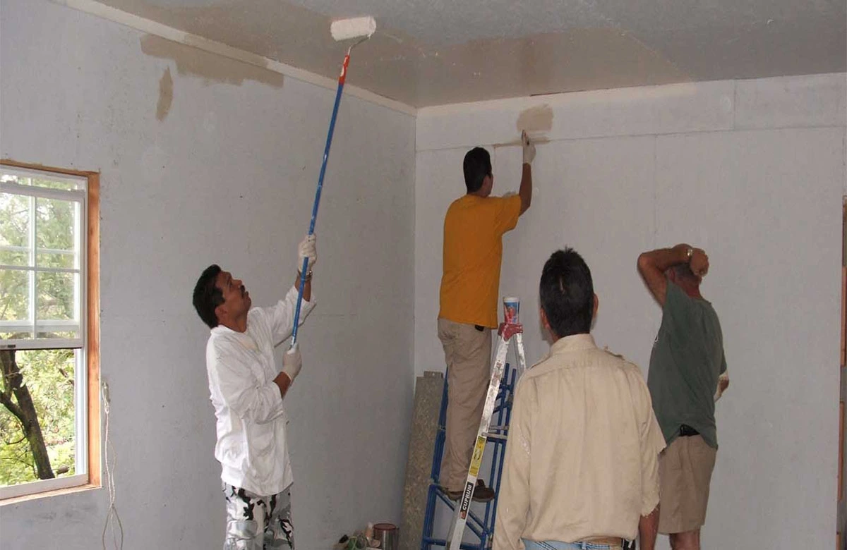 Team of professional painters working together to paint interior walls and ceiling of a house. Best painters in dubai