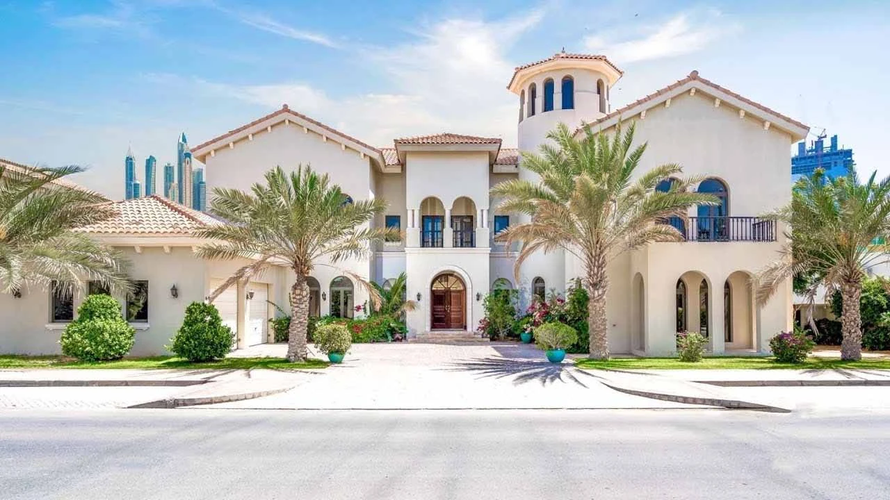 Mediterranean villa with tower feature and palm trees with Dubai skyline in background
