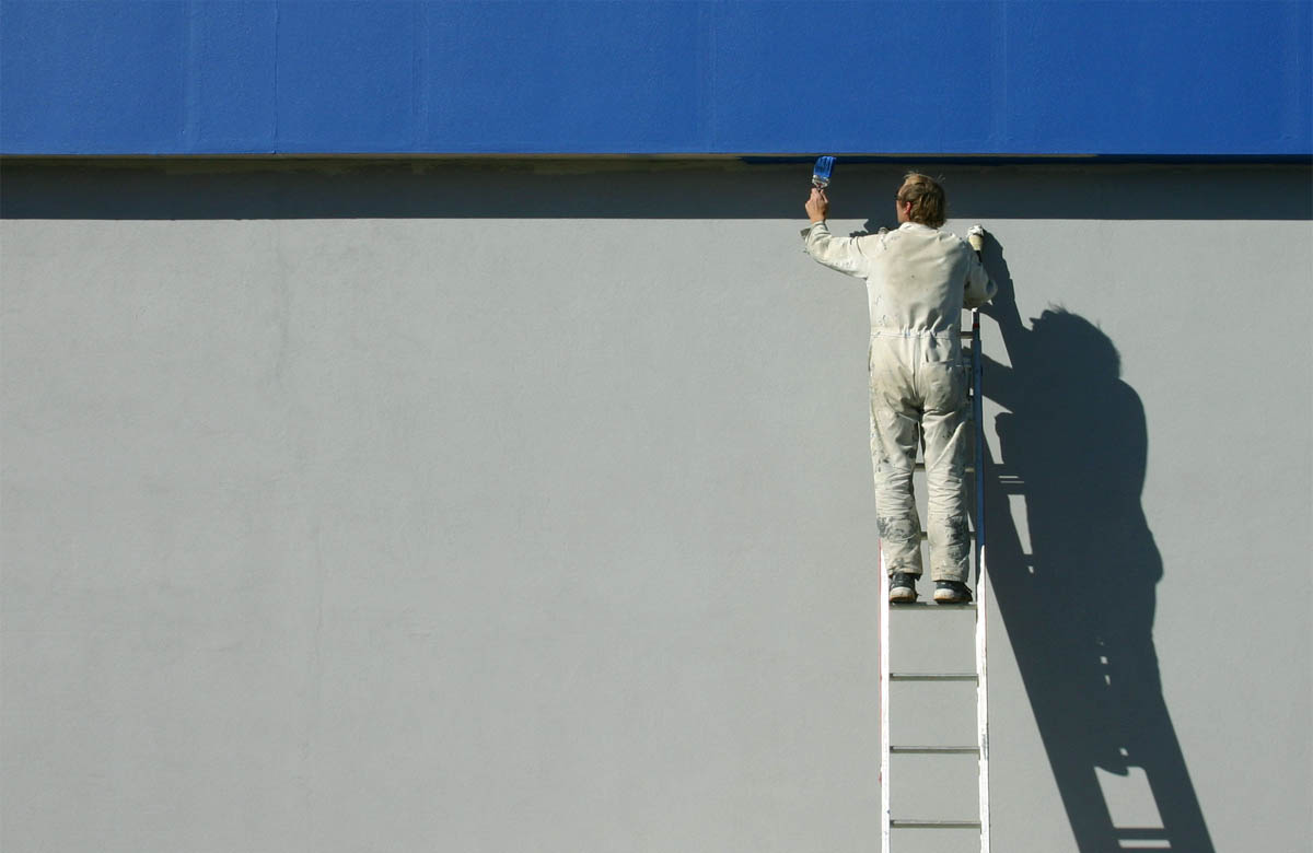 Business interior being painted by professionals with tools and scaffolding, showing how to choose the right commercial painting contractors in Dubai.